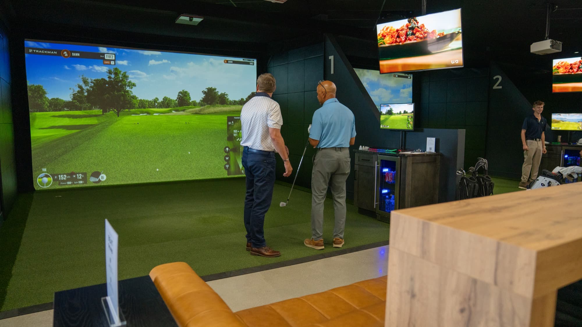 A golf pro giving instruction to a guest at Unbound Golf
