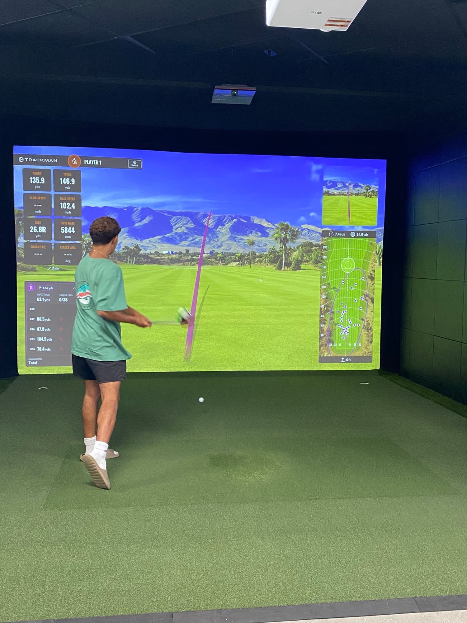 A golfer taking a swing on a Trackman simulator at Unbound Golf