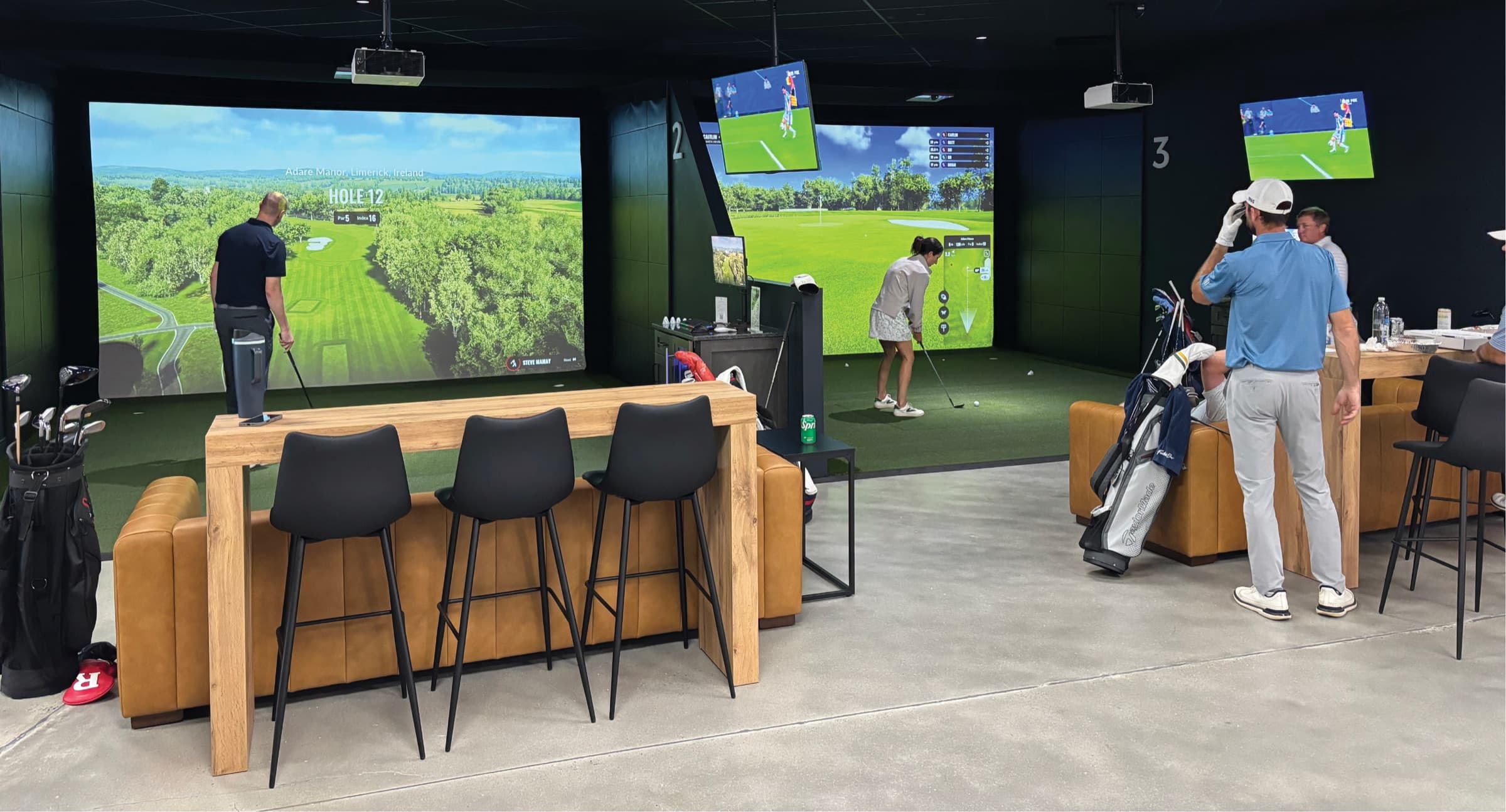 Golfers playing in the open Trackman simulator bays at Unbound Golf in Branchburg, NJ